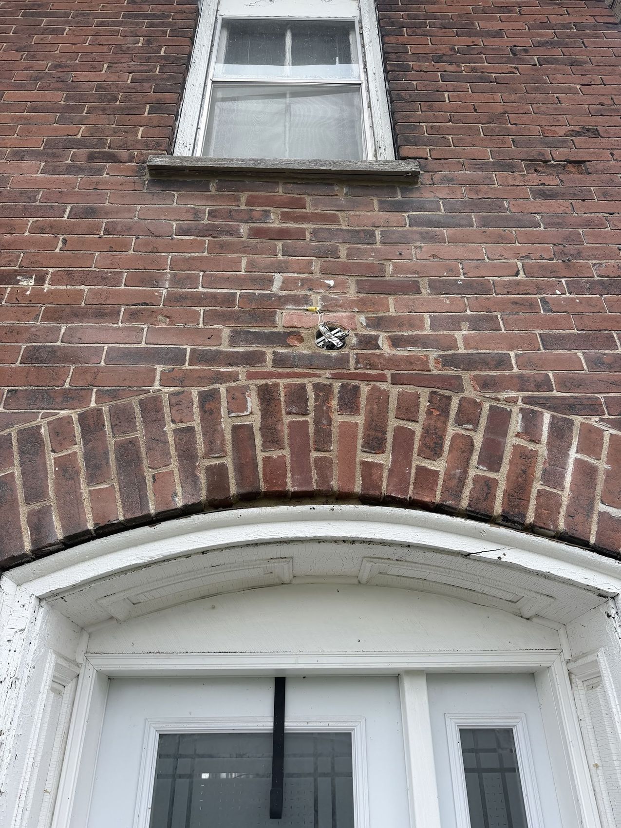 Old brick wall with a brick arch over an arched door