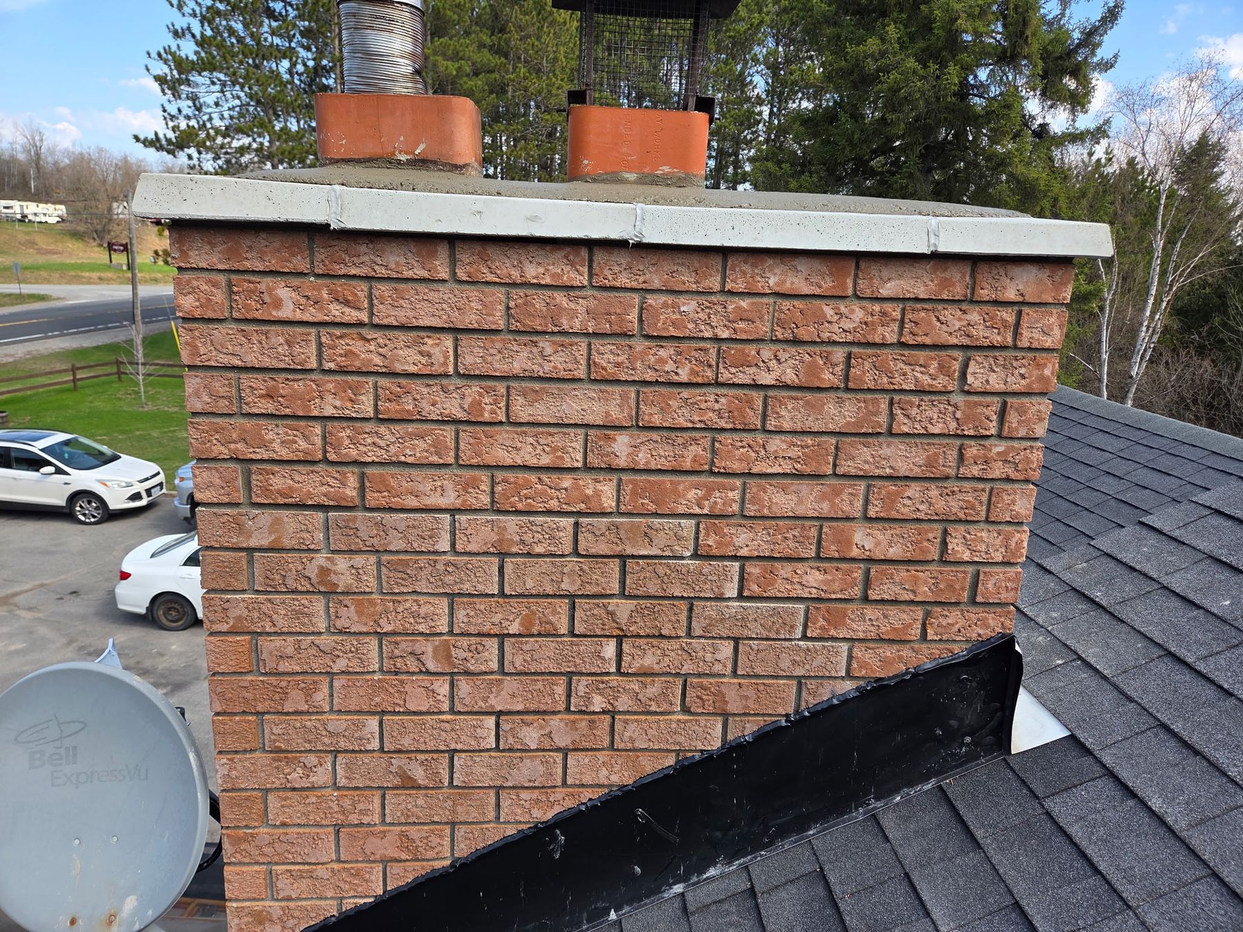 Rebuilt red-brick chimney with a new crown on a shingle roof